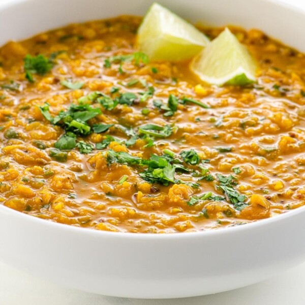 Red Lentil Dahl with Coconut Milk in a bowl with lime and cilantro garnish
