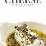 marinated goat cheese appetizer with olive oil and spices in an orange serving dish