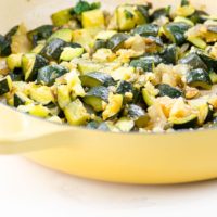 sautéed zucchini and onions in a yellow pan