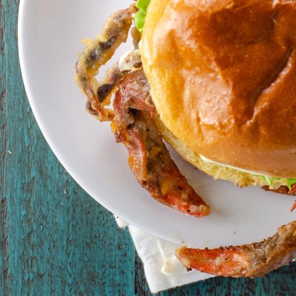 soft shell crab sandwich with lettuce, tomato, and mayo on a brioche bun