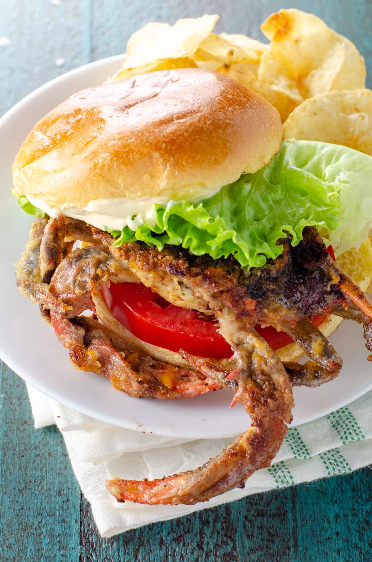 soft shell crab sandwich with lettuce, tomato, and mayo on a brioche bun