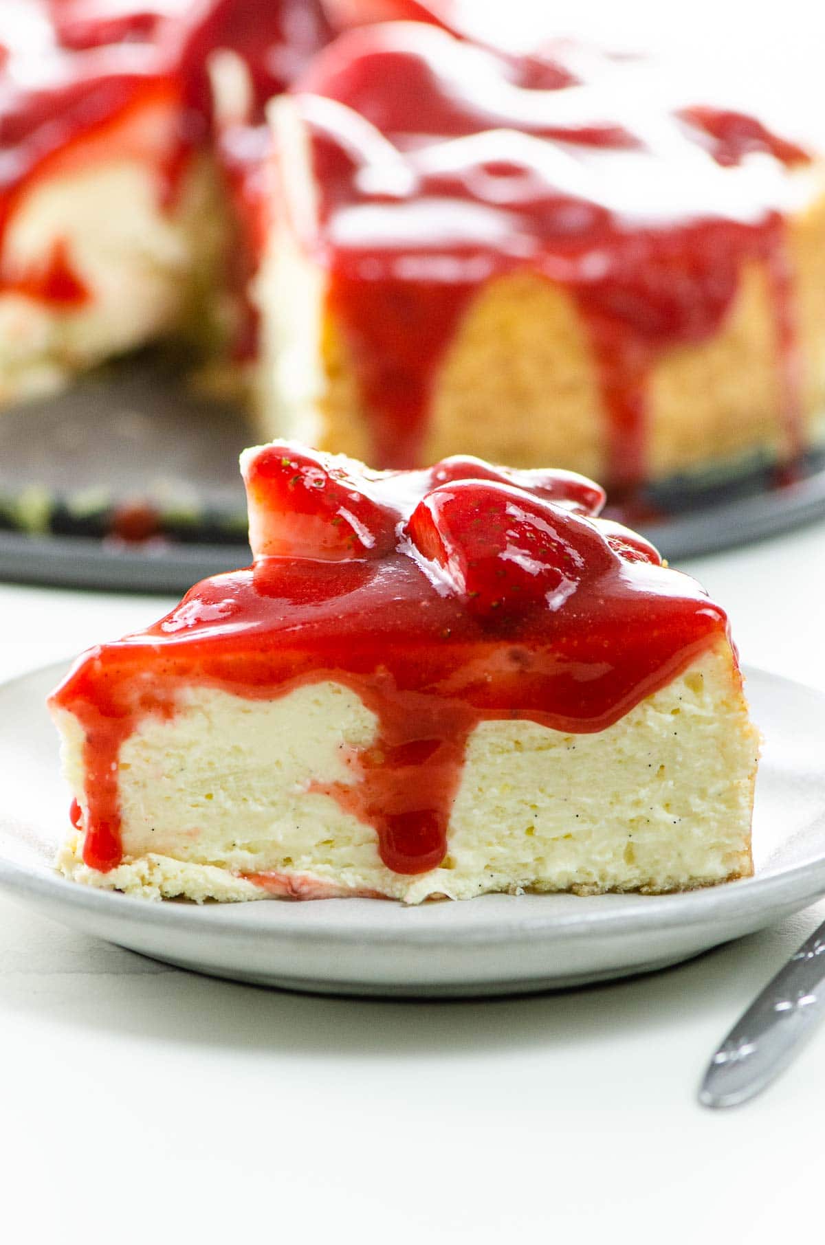 Vanilla bean cheesecake with strawberry sauce