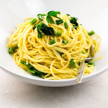 vegetarian carbonara with asparagus and ramps in a white bowl