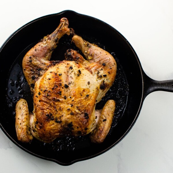 a roasted spatchcock chicken in a cast iron skillet