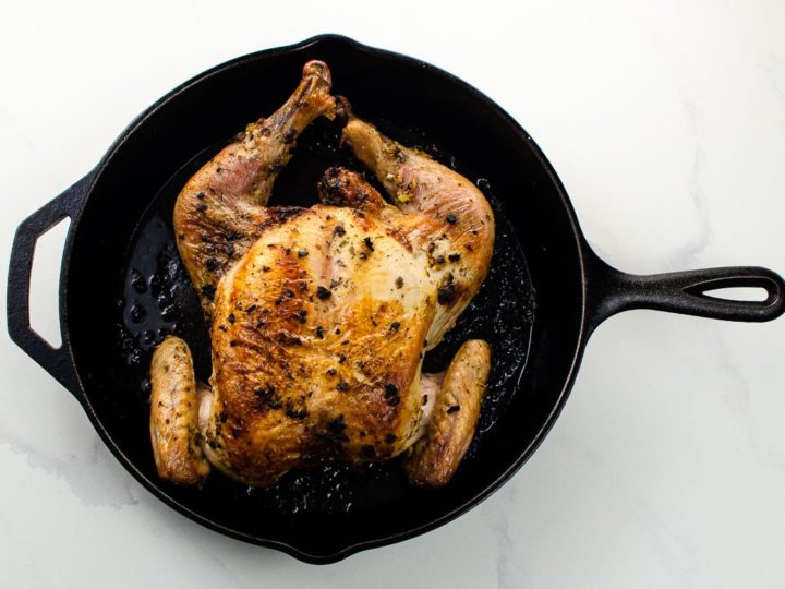 a roasted spatchcock chicken in a cast iron skillet