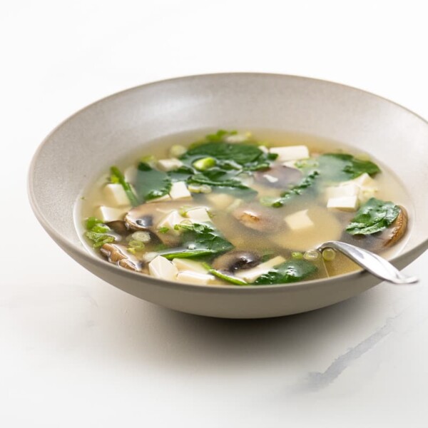 miso soup with mushrooms and spinach in a bowl with a spoon
