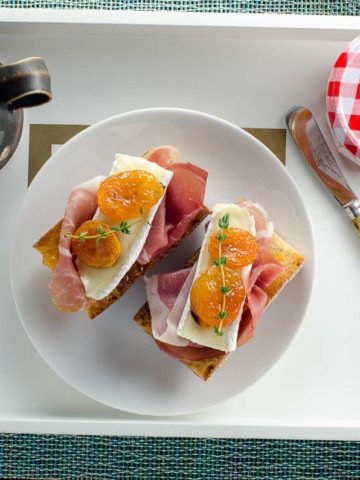 prosicutto brie and apricot toasts on a tray with coffee for mother's day breakfast in bed
