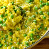 saffron risotto with goat cheese and peas in a pan