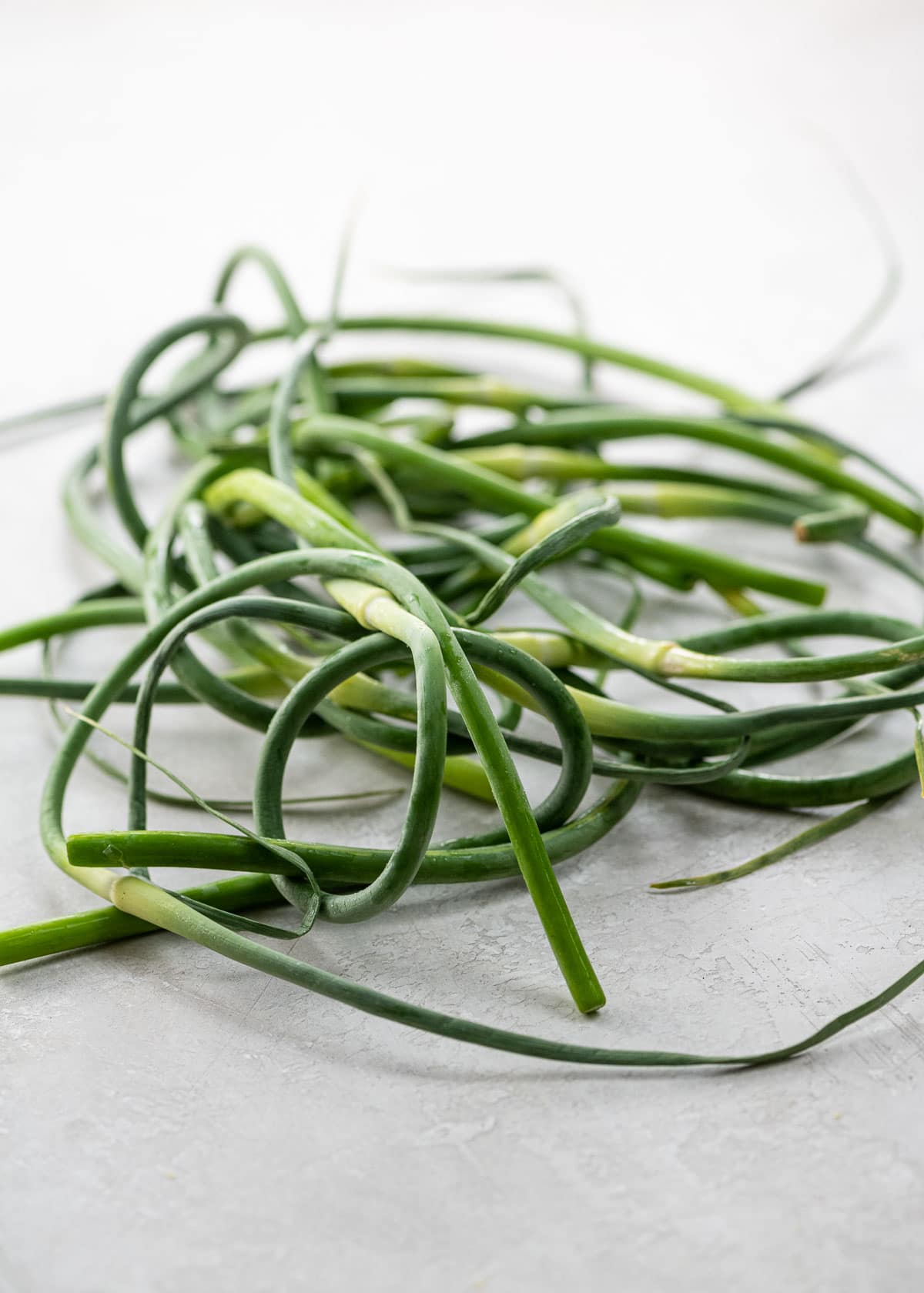 a tangle of garlic scapes on a light background