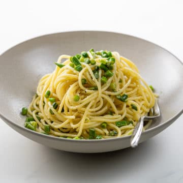 spaghetti with sliced garlic scapes in a bowl