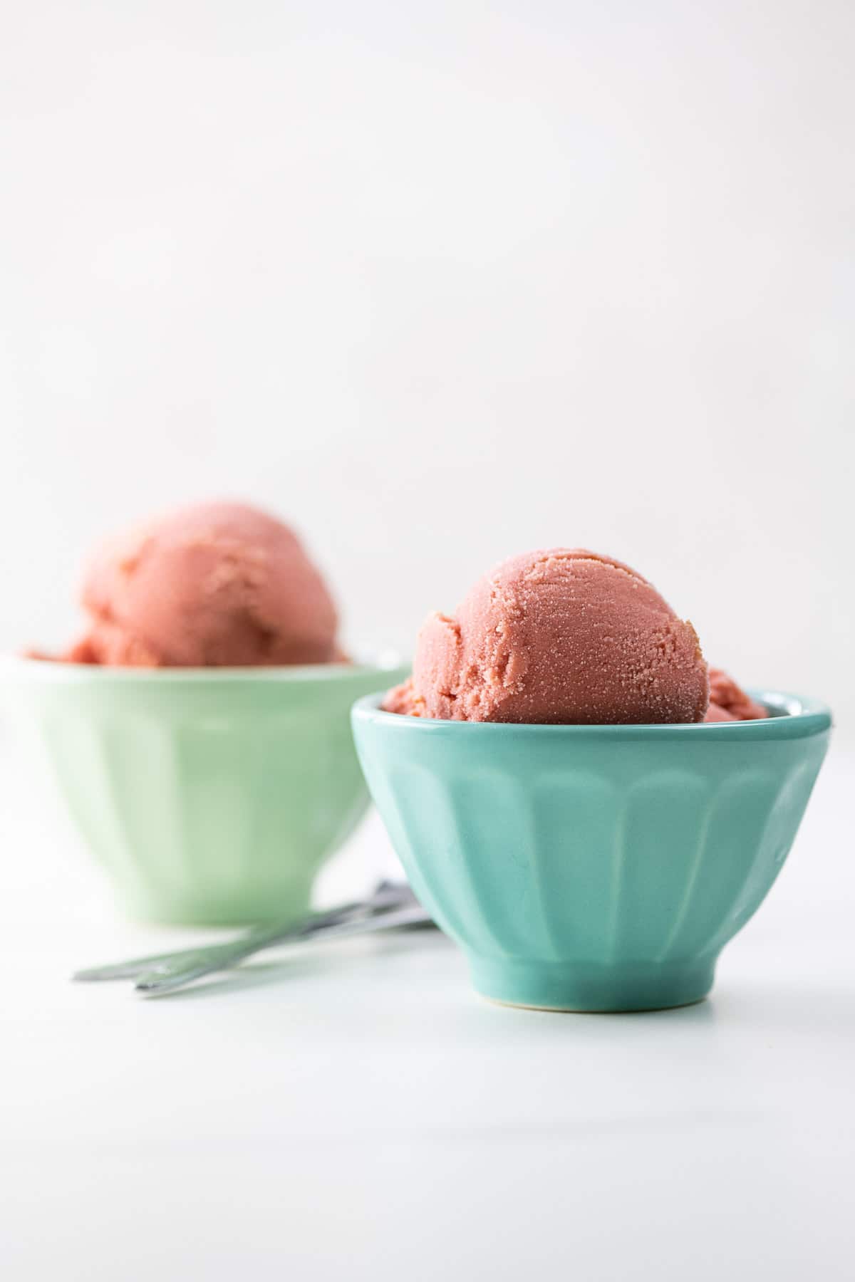 sour cherry frozen yogurt scooped into small bowls with spoons
