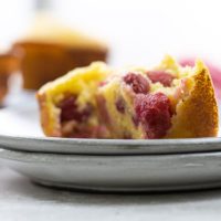 a sour cherry muffin on plates with more on a cooling rack