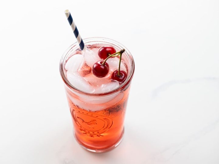 shirley temple recipe with sour cherries in a glass with a straw
