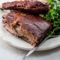 St. Louis ribs, kale salad, and macaroni and cheese on a plate