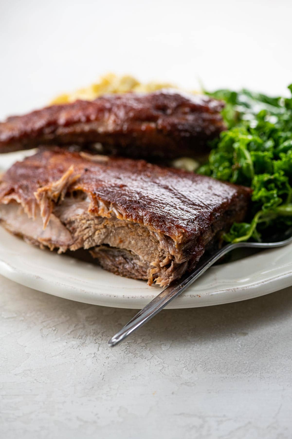 St. Louis ribs, kale salad, and macaroni and cheese on a plate
