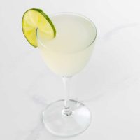 classic daiquiri in a nick and nora glass with a lime wheel garnish