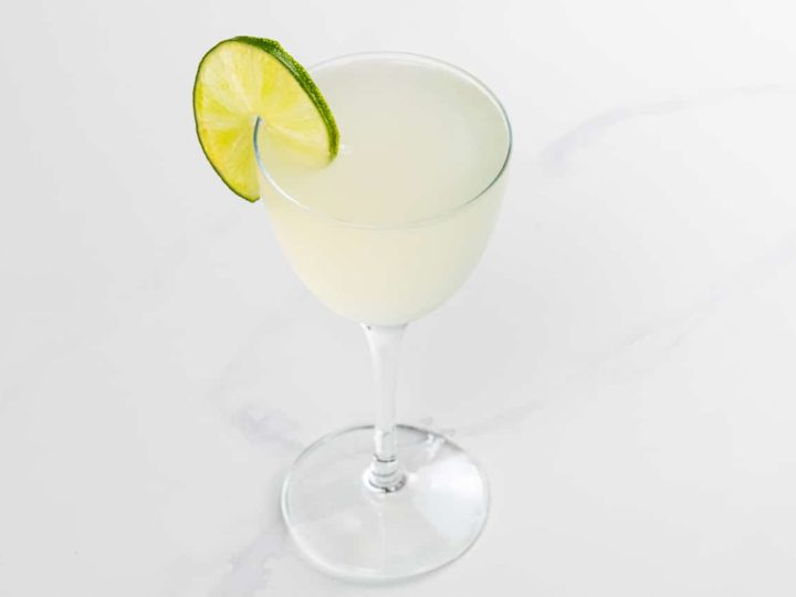 classic daiquiri in a nick and nora glass with a lime wheel garnish