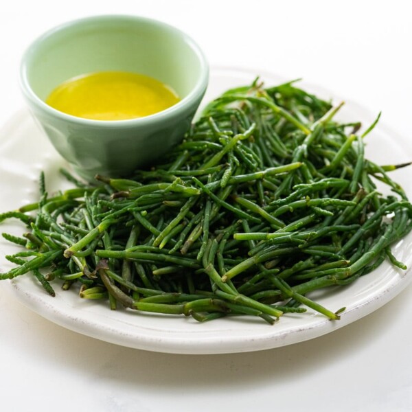 sea beans on a plate with a bowl of lemon butter for dipping