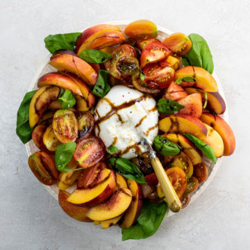 burrata caprese salad with nectarines on a serving plate