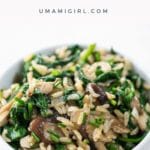 mushrooms and rice with spinach in a white bowl