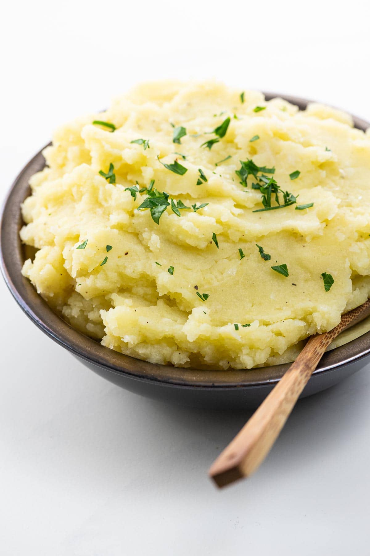 wasabi mashed potatoes in a bowl with a wooden spoon