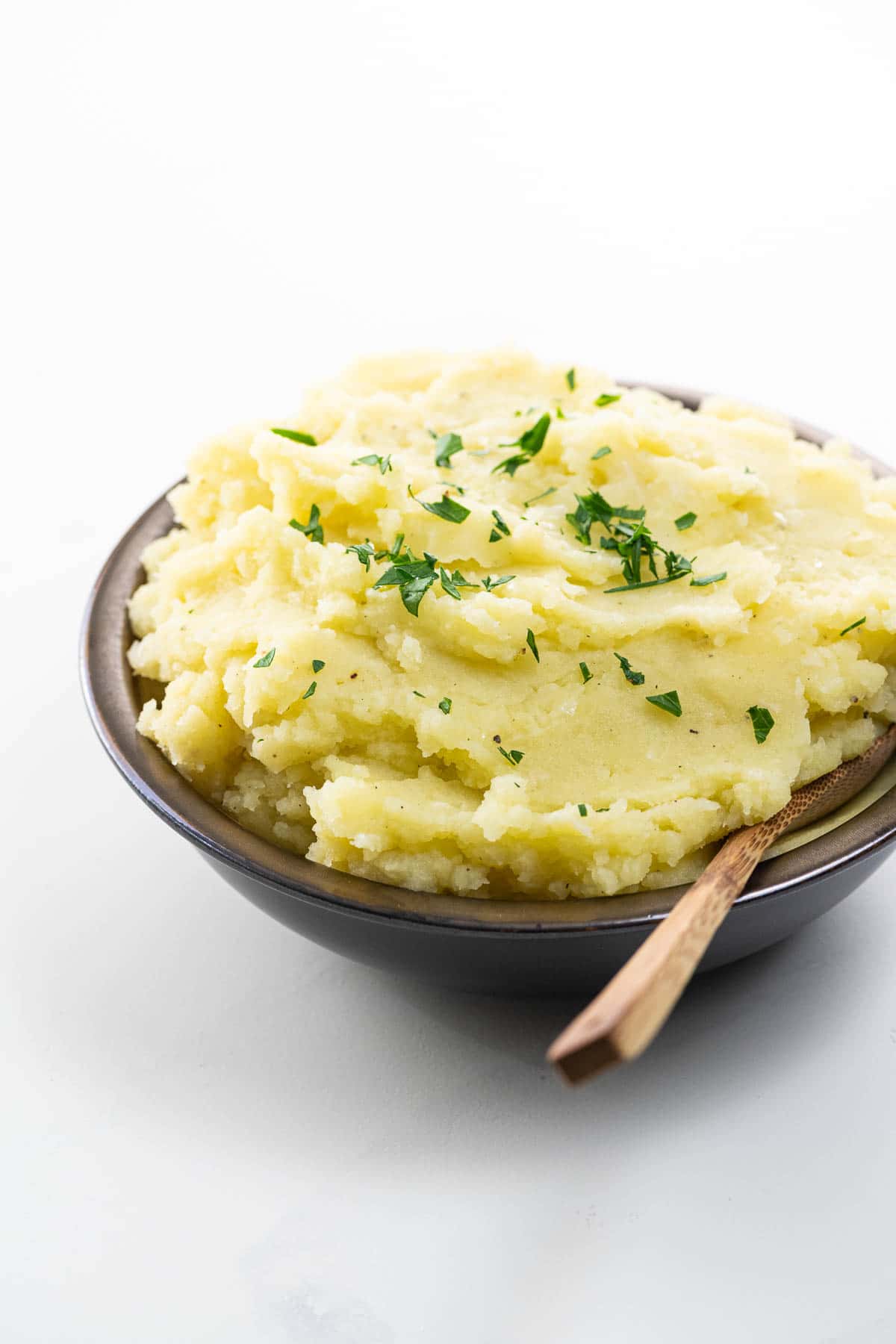 wasabi mashed potatoes in a bowl with a wooden spoon