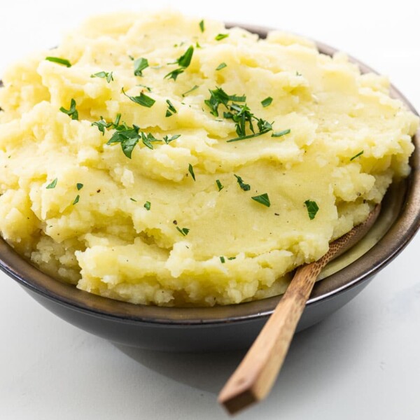 wasabi mashed potatoes in a bowl with a wooden spoon