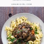 bouef bourguignon over egg noodles in a bowl with a fork