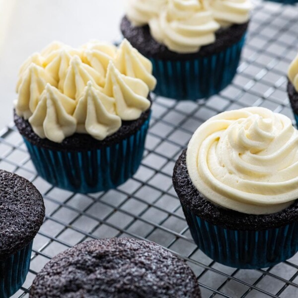 chocolate cupcakes with cream cheese frosting on a cooling rack
