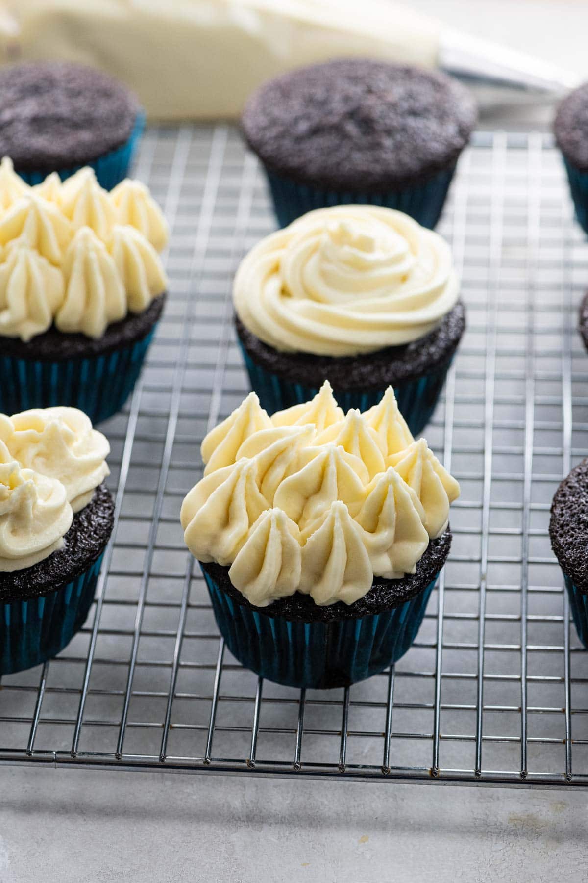 chocolate cupcakes with cream cheese frosting on a cooling rack