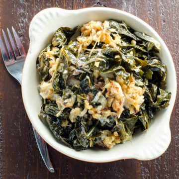braised kale with caramelized onions, walnuts, and blue cheese in a gratin dish with a fork