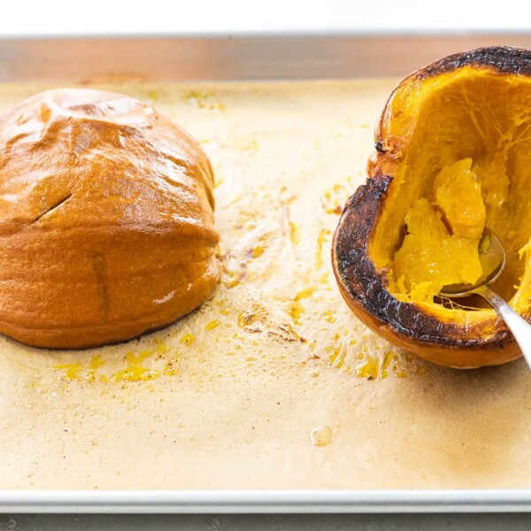 roasted pumpkin on a baking sheet with a spoon