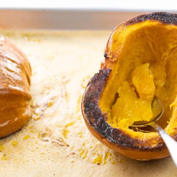 roasted pumpkin on a baking sheet with a spoon