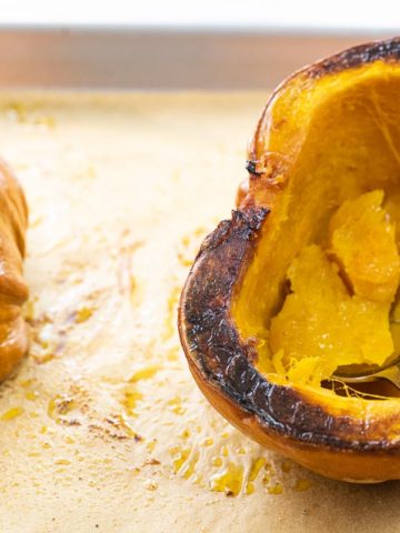 roasted pumpkin on a baking sheet with a spoon