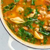 Italian sausage soup with white beans and spinach in a pot