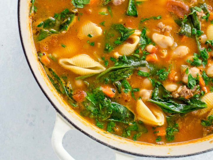 Italian sausage soup with white beans and spinach in a pot