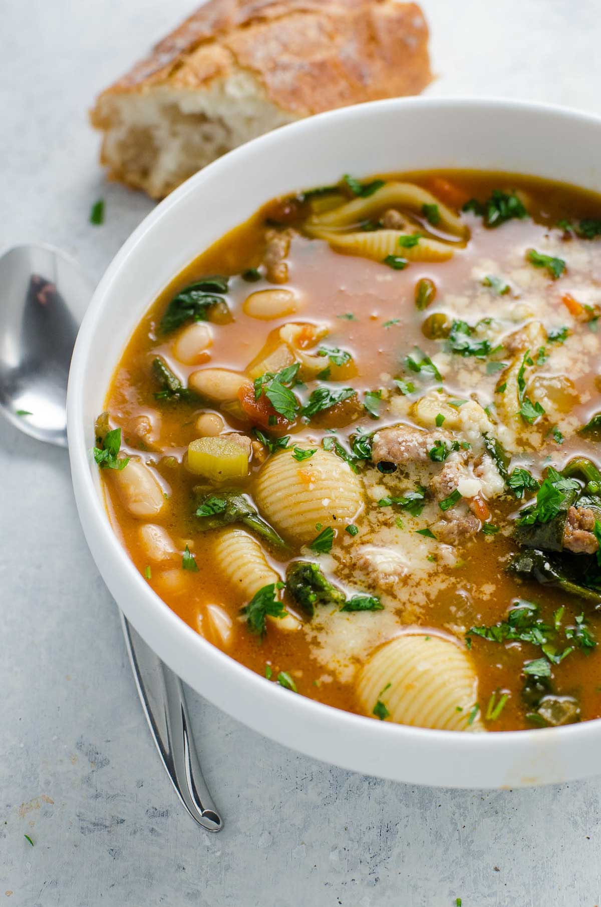 Italian sausage soup with white beans and spinach in a bowl