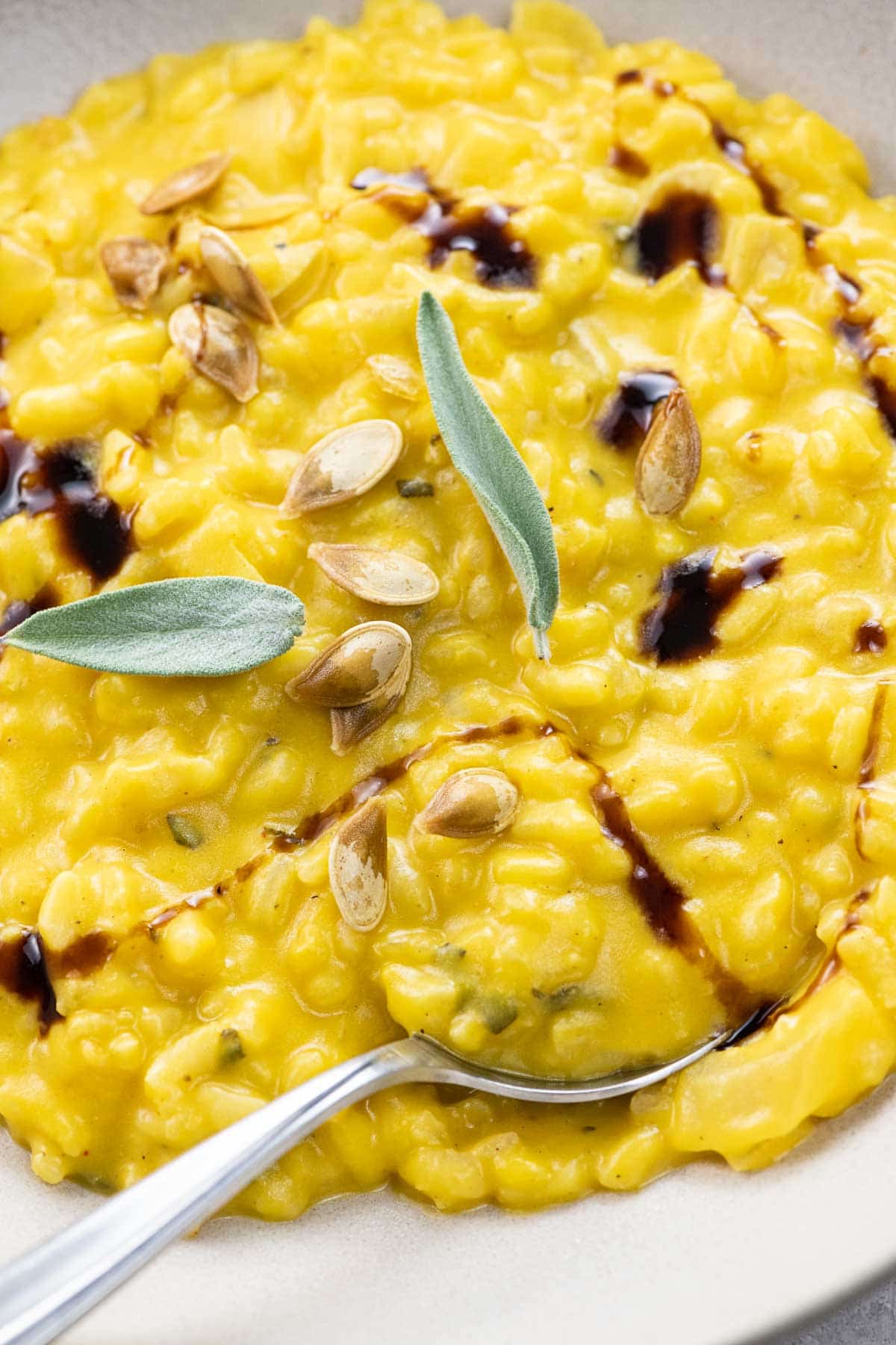 creamy roast pumpkin risotto with sage in a wide, shallow bowl