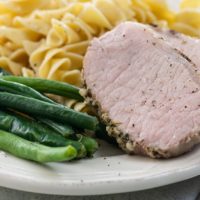 sous vide pork roast, green beans, and egg noodles on a plate