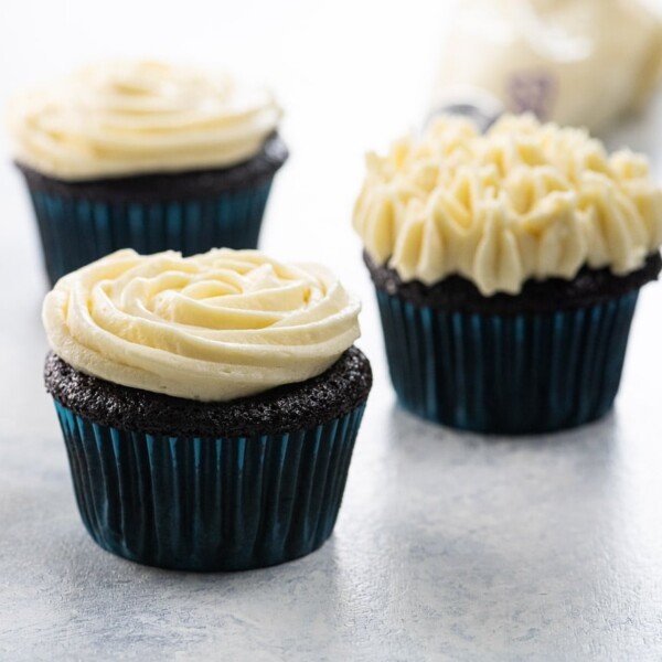 chocolate cupcakes with stable whipped cream cheese frosting for piping, and frosting in a piping bag