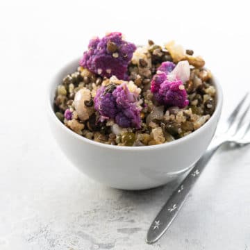 warm quinoa salad with lentils and cauliflower in a white bowl