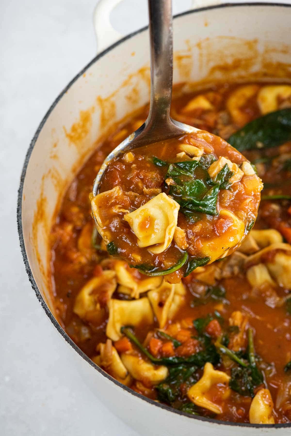 creamy chicken tortellini soup in a pot and a ladle