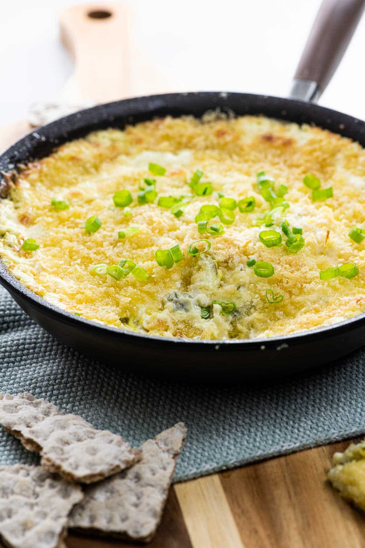 popper dip (jalapeno dip with cream cheese and panko) in a skillet with crackers
