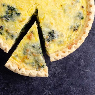 quiche florentine (spinach quiche) with a slice cut out and a small knife