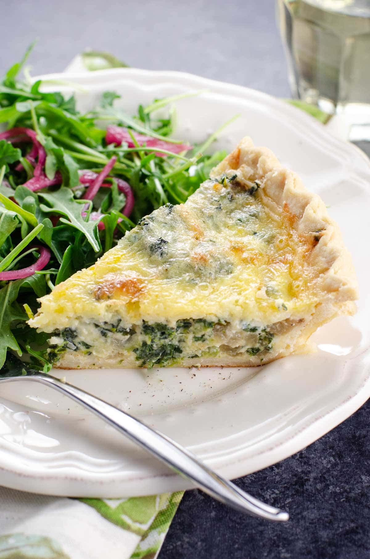 a slice of Quiche Florentine and salad on a plate