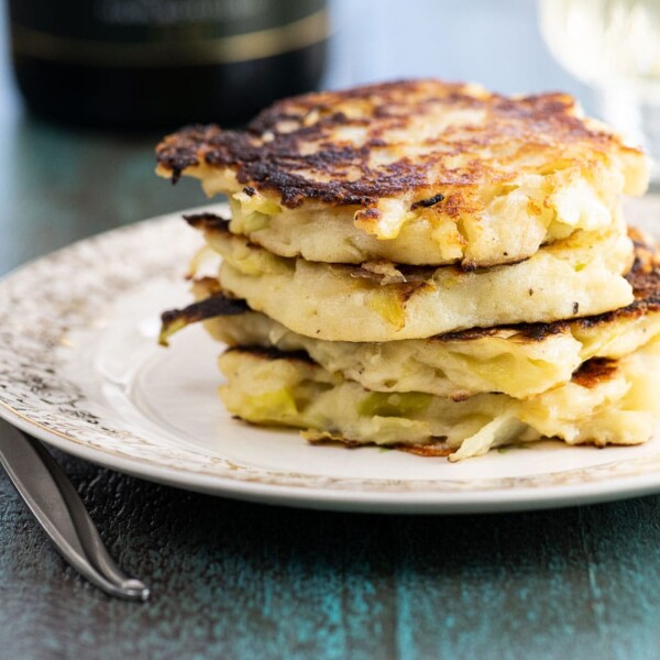 colcannon cheddar skillet cakes on a plate with a glass of wine