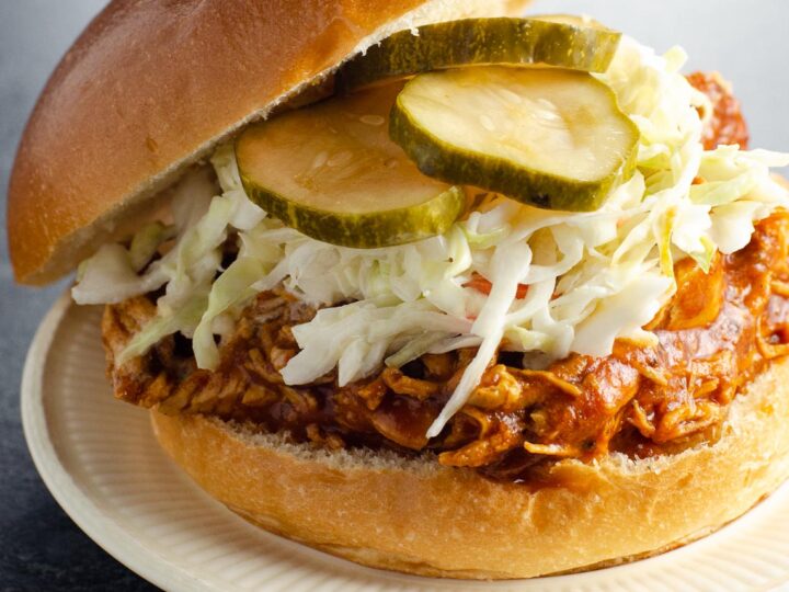instant pot bbq chicken on a roll with coleslaw and pickles