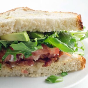 a BLAT sandwich on a small white plate