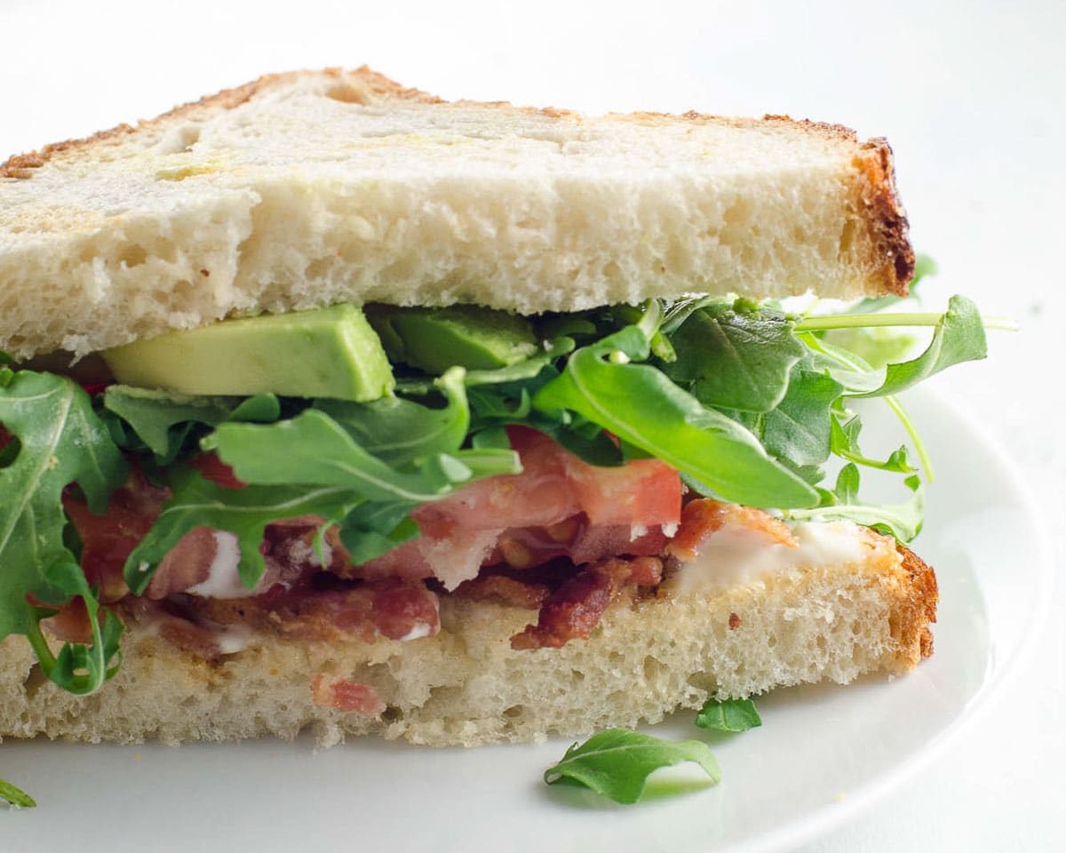 a BLAT sandwich on a small white plate