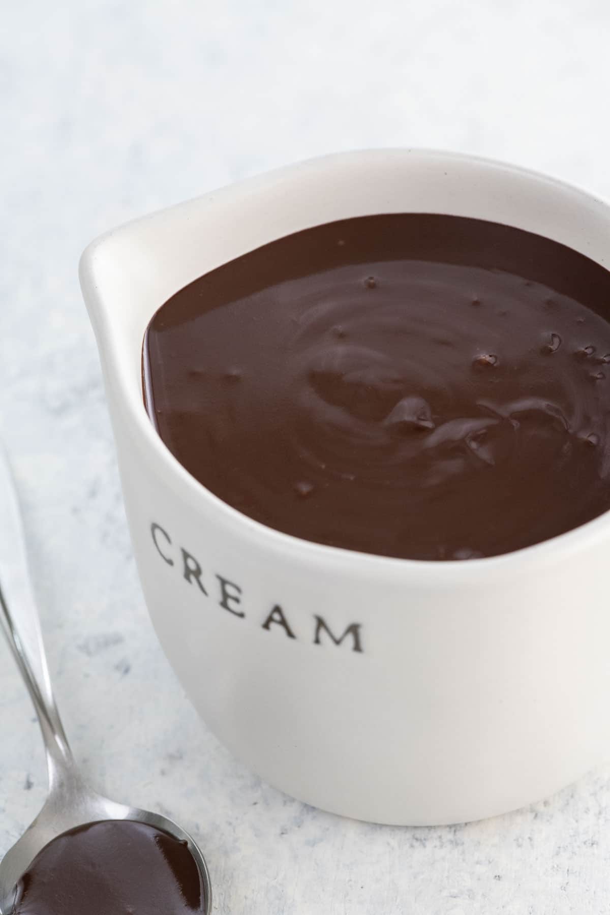 chocolate ganache ratio 1 to 1 in a small pitcher and on a spoon
